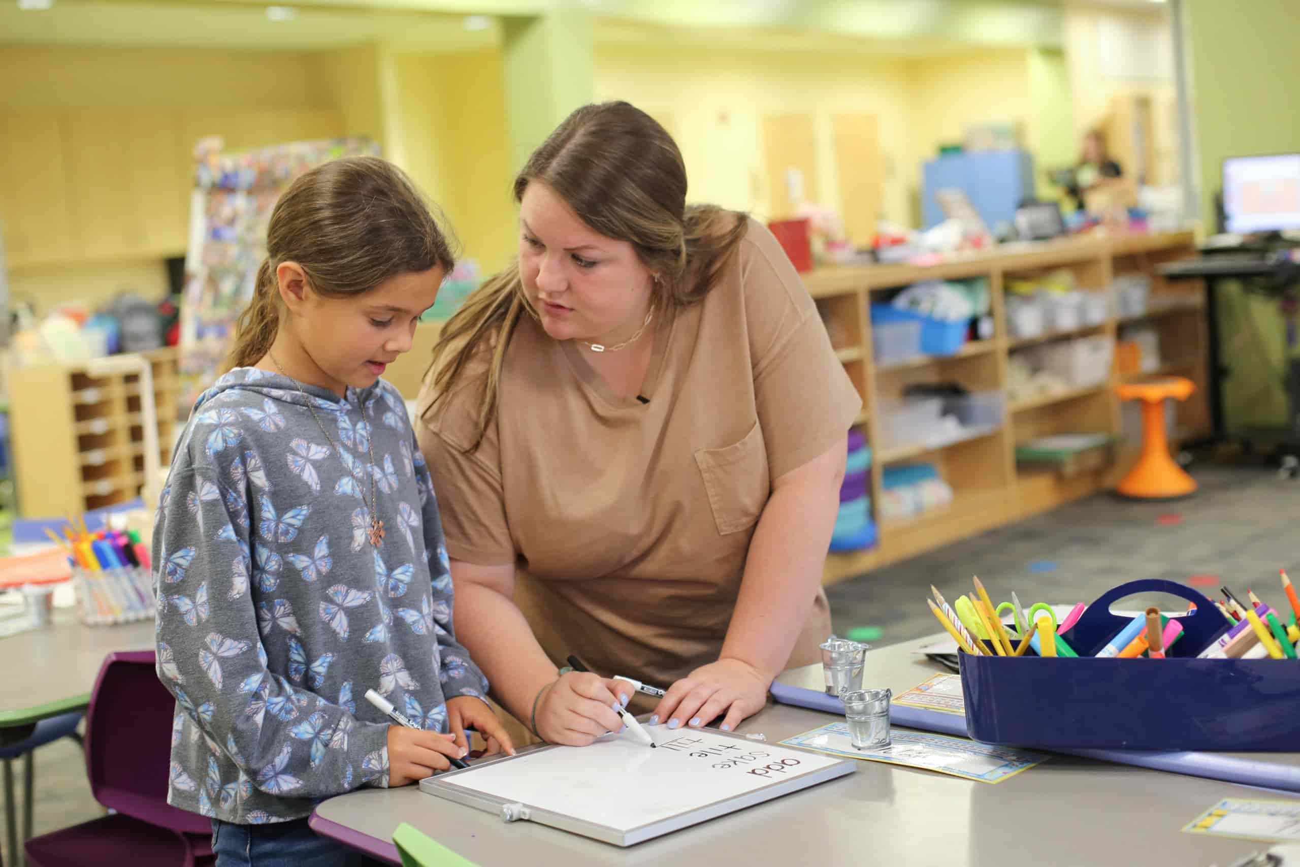 A math teacher helping a student with a math problem.